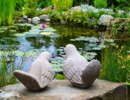 Ein paar Vögel - Gartenskulptur vor einem Teich