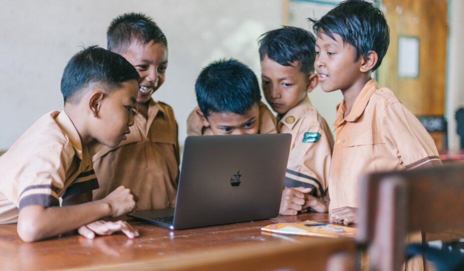 Kinder um einen Macbook