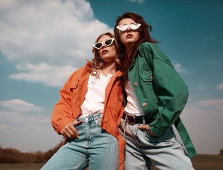 High-Fashion-Porträt zweier stilvoller, schöner Frauen in trendigen Jacken und Jeans, die im Freien posieren. Vogue-Stil.