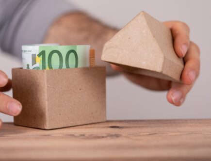 Haus aus Pappe mit Geldscheinen gefüllt | Wasserfilteranlage