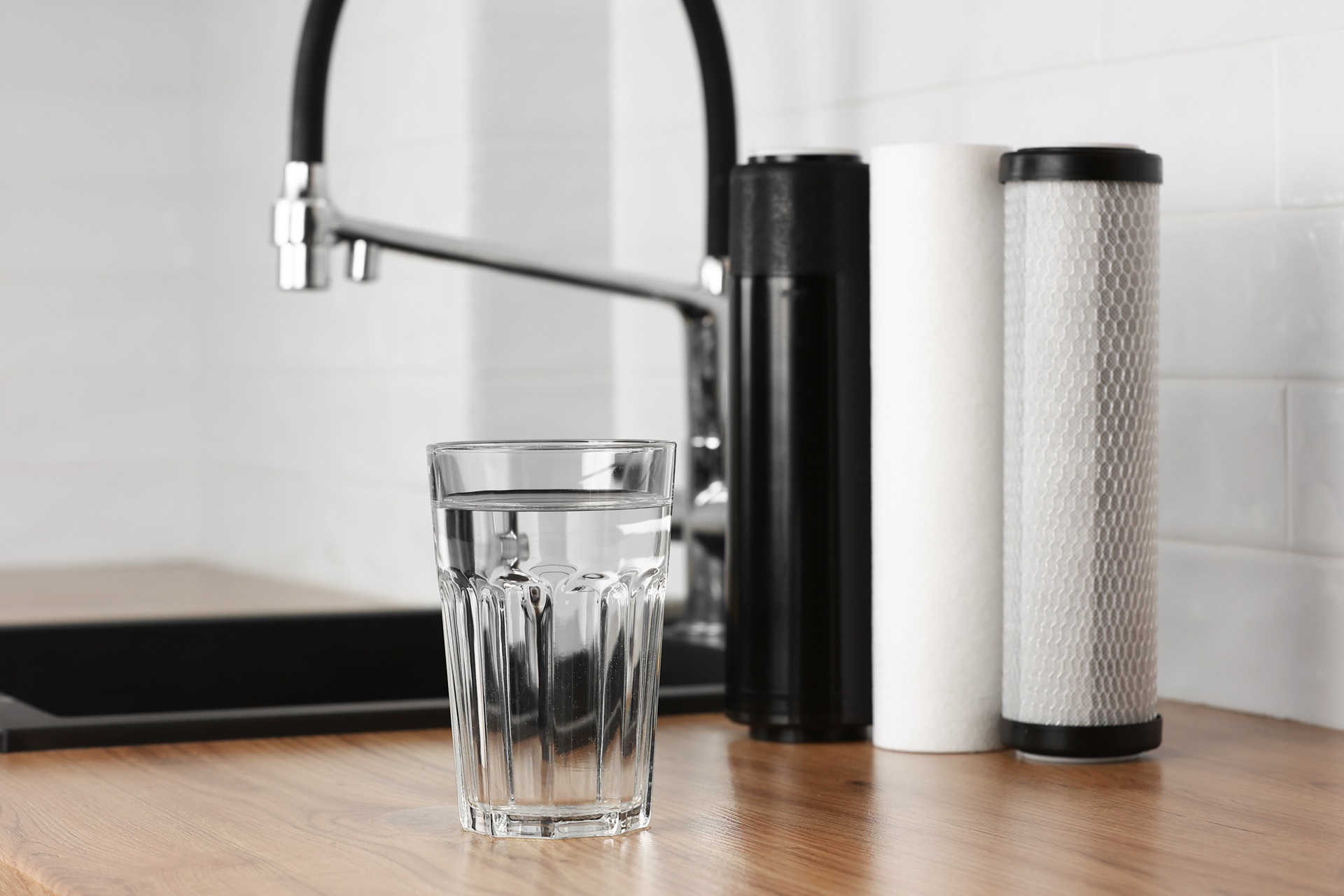 Glas sauberes Wasser neben Filterkartuschen | Wasserfilteranlage