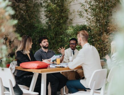 Teammeeting im Freien an Holztisch | Terrassenüberdachung Düsseldorf