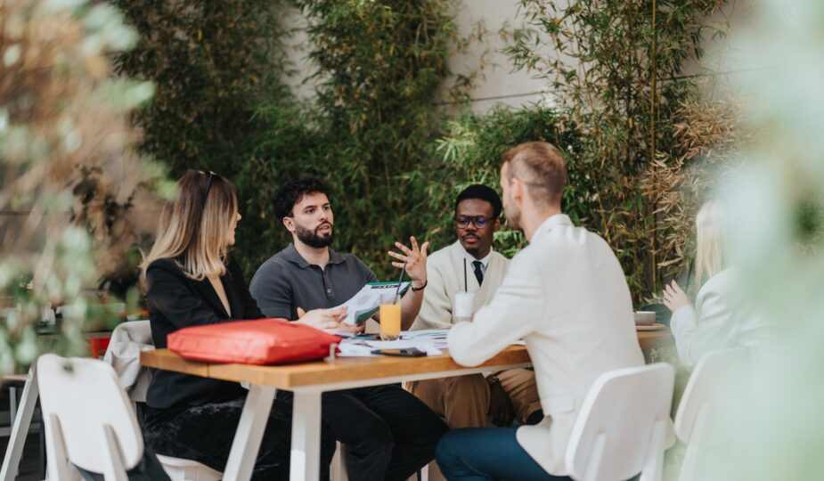Teammeeting im Freien an Holztisch | Terrassenüberdachung Düsseldorf