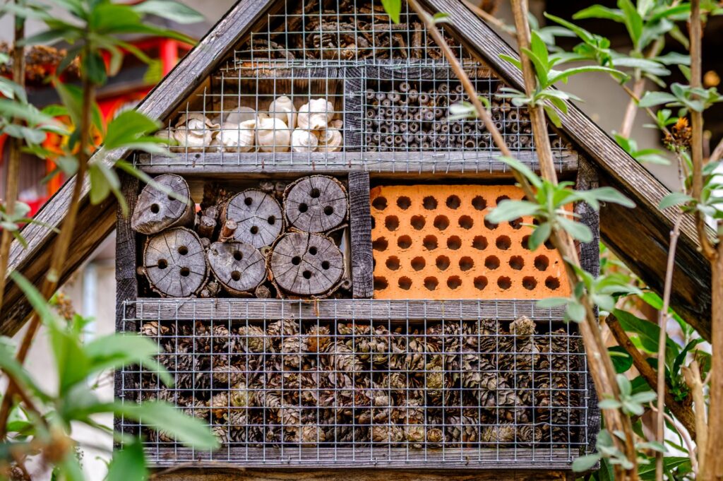 Insektenhotel als Nisthilfe im Garten mit Holz und Naturmaterialien